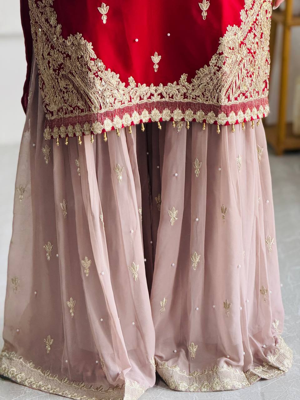 Maroon red embroidered kameez sharara with gold embroidery.